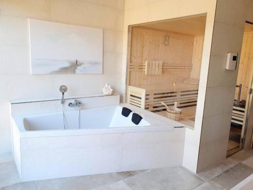 岑平Ferienhaus Inselliebe mit Sauna的带淋浴的浴室配有白色浴缸。