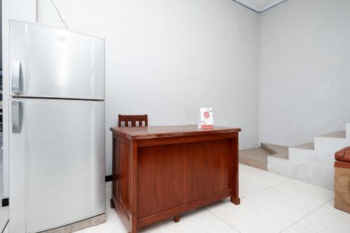 梭罗OYO 2058 Griya Ria的厨房配有冰箱和木桌
