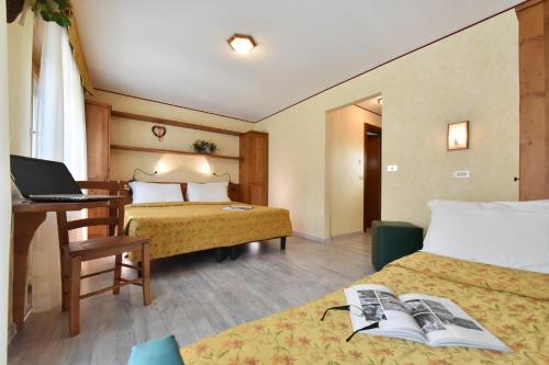 瓦托内切比久酒店的酒店客房配有两张床和一张带笔记本电脑的书桌