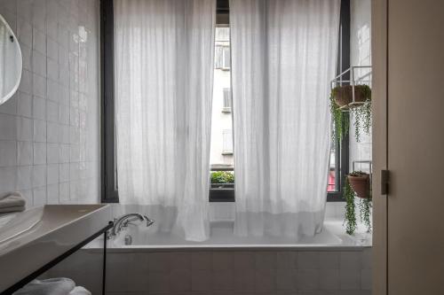 阿尔勒Maison Volver的浴室设有白色的浴帘和窗户。