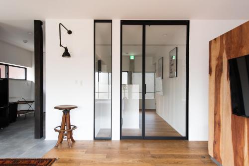 金泽Kamin Kanazawa的一个带凳子的房间的玻璃扇门