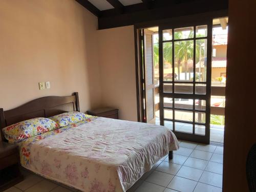 托雷斯Vô Doríbio的一间卧室设有一张床和一个滑动玻璃门