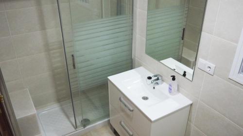 罗塔APARTAMENTO VILLA DE ROTA - VISTA MAR, 135m2, Terraza, SAT TV y más的带淋浴、盥洗盆和镜子的浴室