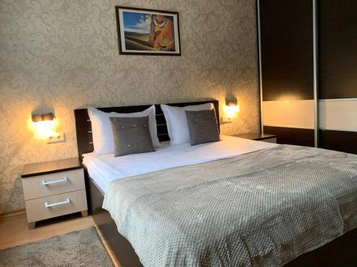 波罗维茨GM Royal Plaza的一间卧室配有一张大床和两盏灯。