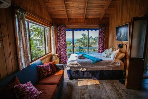 文森提亚Marazul Paradise Beach House- Panoramic Ocean Views的一间卧室配有一张床、一张沙发和一个窗口