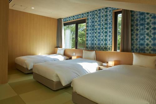 箱根箱根优托瓦酒店(Hakone Yutowa)的酒店客房设有两张床和窗户。