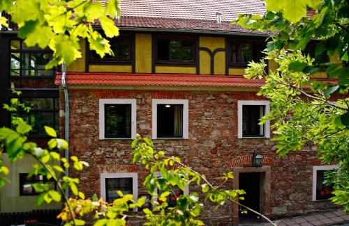 斯雷布纳古拉Centrum Turystyki Niekonwencjonalnej的一座古老的砖砌建筑,拥有白色的窗户和树木