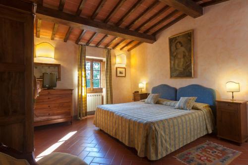 瓦尔的圣卡西亚诺黎莱斯波吉欧博尔戈尼酒店的一间卧室配有一张床、梳妆台和电视。
