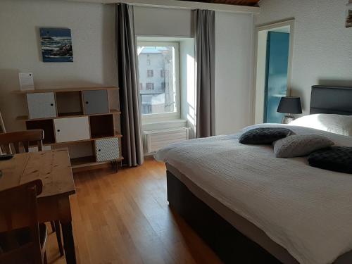 勒沙布勒乐吉特罗兹餐厅酒店的一间卧室配有一张床、一张桌子和一个窗户。