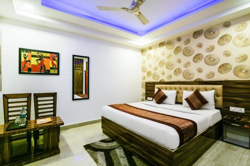 新德里Hotel Pearl - Mahipalpur Delhi Airport的一张床铺、一张桌子和一张床