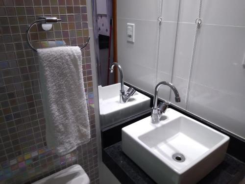 卡波布里奥Apartamento Praia do Forte VIP的一间带水槽、卫生间和镜子的浴室