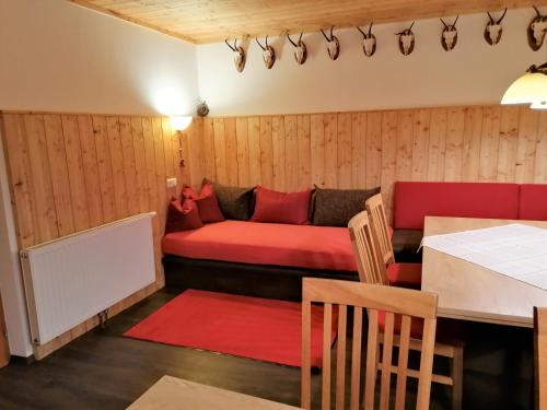 克森Ferienhaus Sonnhof am Walchsee的一间设有红色沙发和桌子的房间