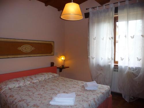 普拉托韦基奥MAGNOLIA TUSCANY HOUSE WITH POOL Agriturismo Poppiena的一间卧室设有一张床和一个窗口