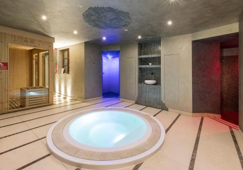 塔尔维西奥艾德霍夫酒店的中间设有大浴缸的大浴室