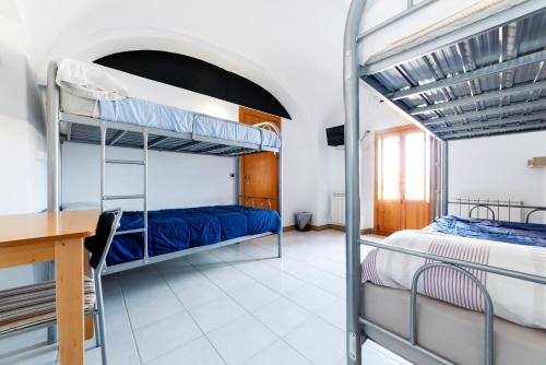 卡塞雷斯Albergue las Veletas的一间卧室配有两张双层床和一张书桌