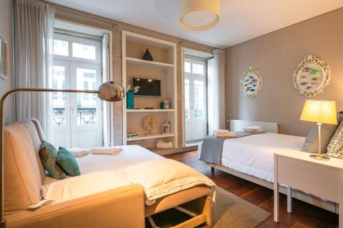 波尔图Cardosas Charming Apartment with Balconies的一间带两张床和一张沙发的卧室