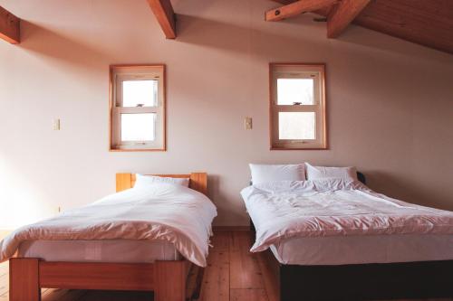 二世古Guest House ONLY ONE的带2扇窗户的客房内的2张床