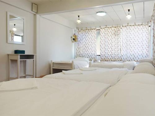 柴老海滩班彬淑度假酒店的白色的客房配有两张床和镜子