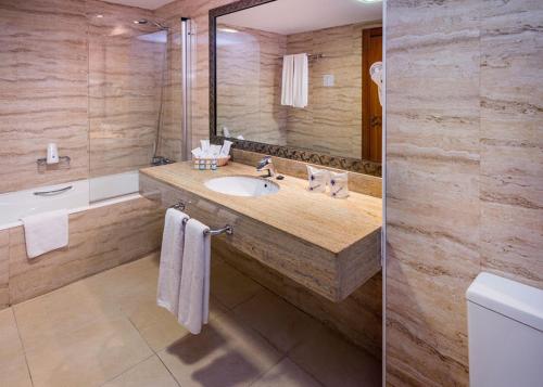 滨海罗克塔斯Mediterraneo Bay Hotel & Resort的一间带水槽和大镜子的浴室