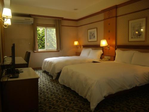 关山镇山水轩渡假村饭店的酒店客房设有两张床和电视。