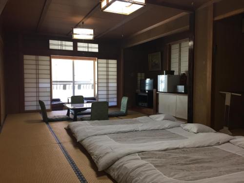 山之内町大丸屋日式旅馆的一间大卧室,配有两张床和一张桌子