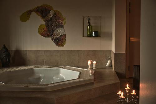 汉斯特霍尔姆Hanstholm Madbar的浴室配有浴缸,浴室内备有蜡烛