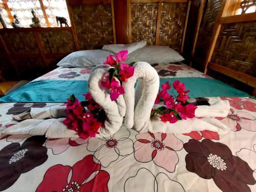 道伊斯MJ Room Rental Mahogany的一张带两条毛巾和鲜花的床