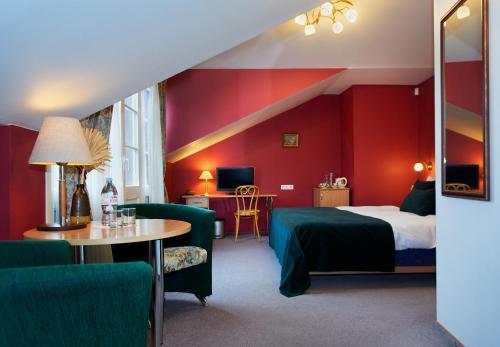 维尔纽斯Angel Town Hall Apartments的酒店客房带一张床、一张桌子和椅子