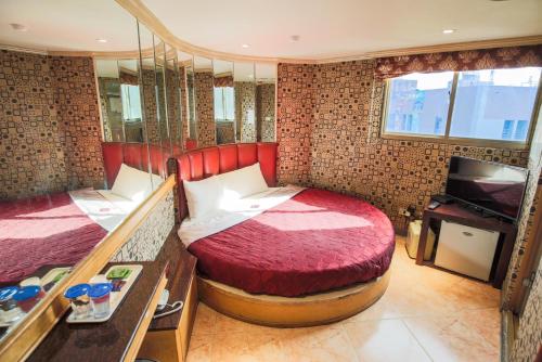 台北百悅旅社的一间卧室配有两张床和电视。