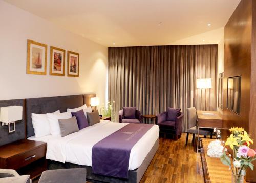 拉合尔Indigo Heights Hotel & Suites的酒店客房设有一张大床和一张书桌。