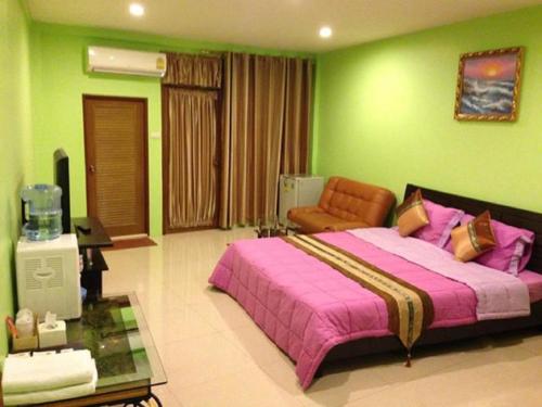 曼谷槟城皇宫酒店的一间卧室设有一张大床和绿色的墙壁