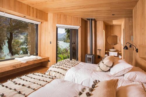 PueloLodge Tagua Tagua, Puelo Patagonia的一间卧室设有两张床和大窗户