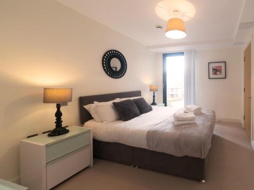 伦敦Central Tower Bridge Apartment的一间卧室配有一张带灯和窗户的床