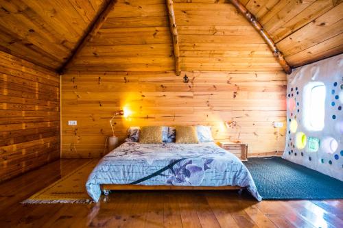 Los EstancosCasa Inspirada的小木屋内一间卧室,配有一张床