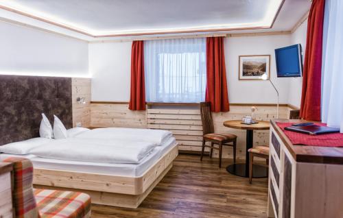 塞尔瓦迪加尔代纳山谷Hotel Garni Aghel的配有一张床和一张书桌的酒店客房