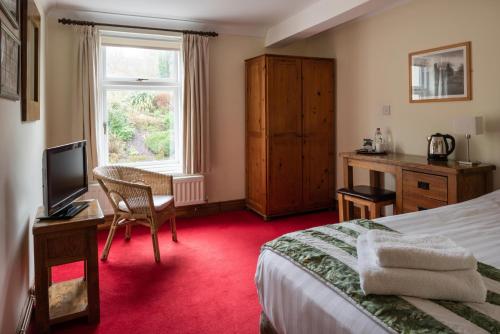 TregaronY Talbot的配有一张床、一张书桌和一扇窗户的酒店客房
