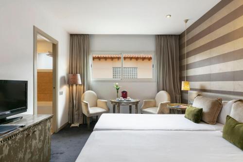 马德里全球亚西斯加勒蒂亚旅馆的酒店客房设有两张床和电视。