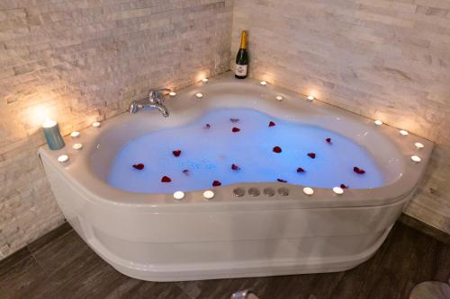 尼什SPA Apartment Nalis的热水浴池(带蜡烛和一瓶葡萄酒)
