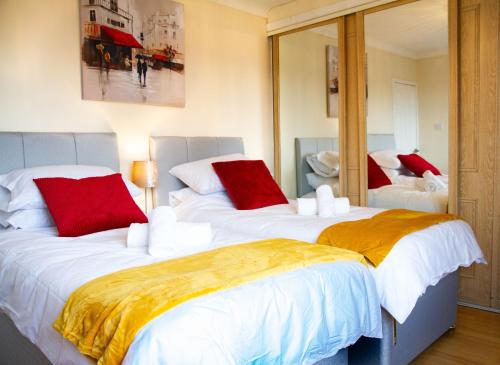 格兰奇茅斯Carvetii - Derwent House - Spacious 2nd floor flat的一间卧室配有两张带红白色枕头的床