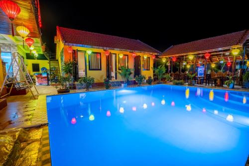 峰牙Phong Nha Ecolodge的夜间在房子前面的游泳池