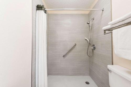 韦科韦科/购物中心面积速8酒店的带淋浴和浴帘的浴室