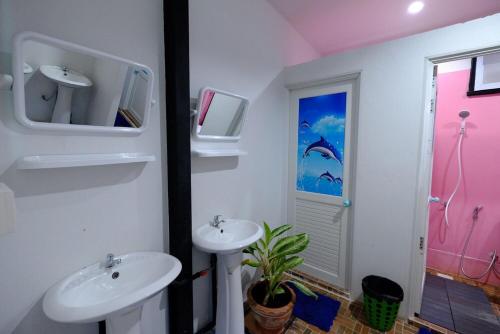 丽贝岛桑昌旅舍的一间带两个盥洗盆的浴室和墙上的电视