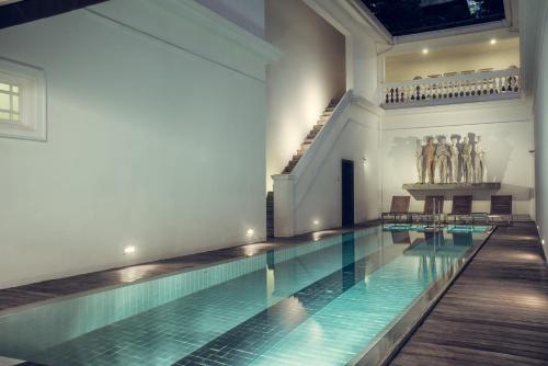 科伦坡天堂之路科伦坡廷塔杰尔酒店的一座大型游泳池,位于一座带游泳池的建筑内