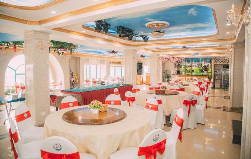 太原省Da Huong Hotel的一间在房间内配有桌椅的餐厅