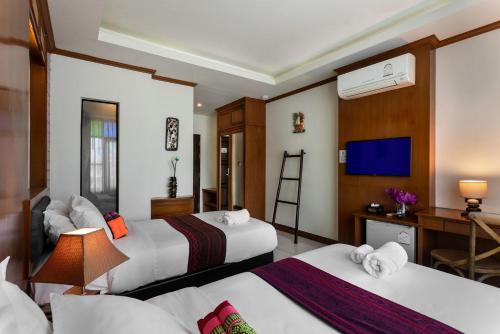 清迈Lee Chiang Hotel的酒店客房配有两张床和一张书桌