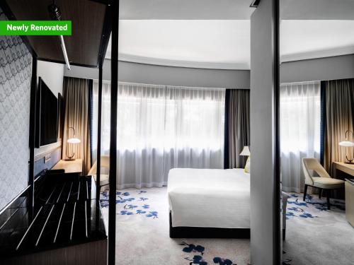 新加坡Copthorne King's Hotel Singapore on Havelock的一张床铺的酒店客房的 ⁇ 染