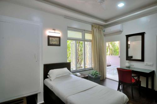 浦那科坦酒店的一间卧室配有一张床、一张书桌和一个窗户。