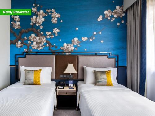 新加坡Copthorne King's Hotel Singapore on Havelock的蓝色墙壁的酒店客房内的两张床