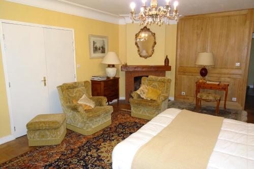 Panazol丰塔尼尔住宿加早餐旅馆的一间卧室配有一张床、两把椅子和一个壁炉