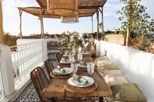 马拉喀什Riad SHIRAZ的阳台配有一张木桌、椅子和一张桌子